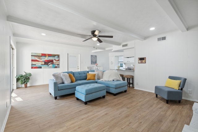 living room featuring ceiling fan, beamed ceiling, and light hardwood / wood-style floors