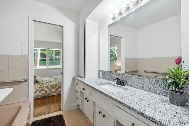 bathroom featuring a washtub, hardwood / wood-style floors, and vanity