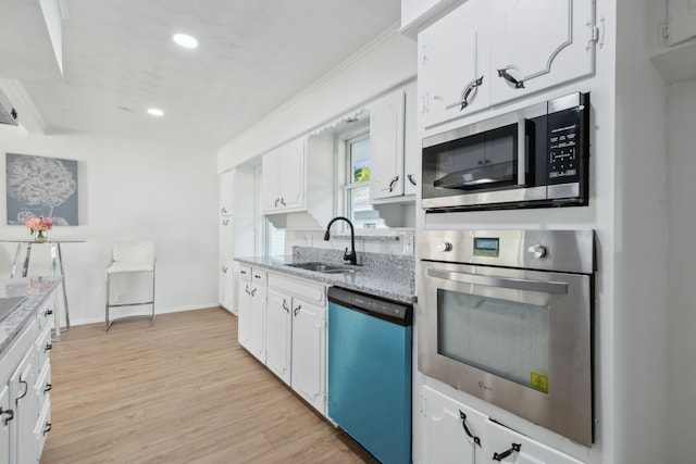 kitchen featuring light hardwood / wood-style floors, sink, stainless steel appliances, ornamental molding, and white cabinets