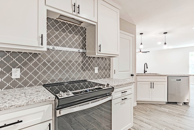 kitchen featuring white cabinets, appliances with stainless steel finishes, hanging light fixtures, and sink