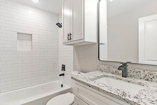 full bathroom featuring tiled shower / bath, vanity, and toilet