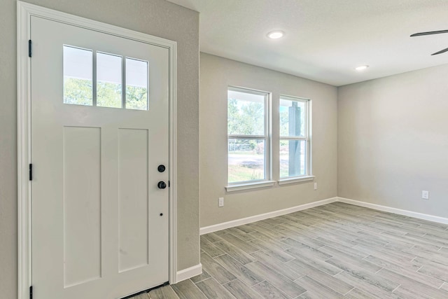 foyer with light wood-type flooring and ceiling fan