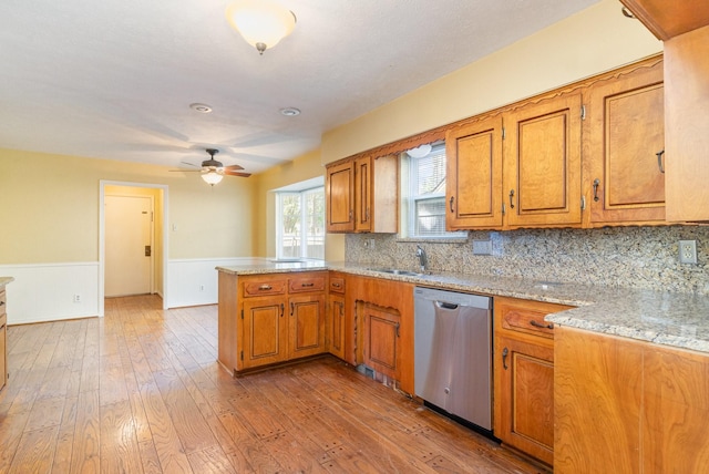 kitchen with dishwasher, sink, light hardwood / wood-style flooring, ceiling fan, and kitchen peninsula