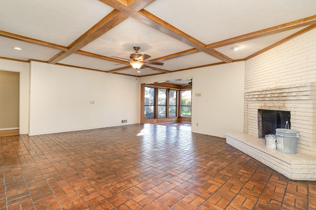 unfurnished living room with ceiling fan, beam ceiling, a fireplace, and coffered ceiling