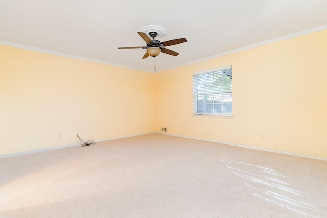 carpeted spare room featuring ceiling fan and ornamental molding