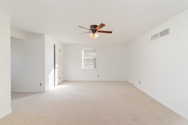 spare room with ceiling fan and light carpet