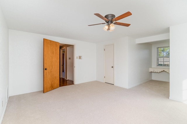 spare room featuring light colored carpet and ceiling fan