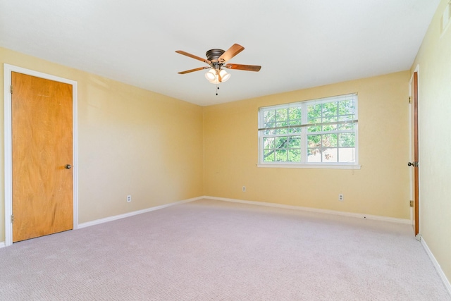 carpeted empty room featuring ceiling fan