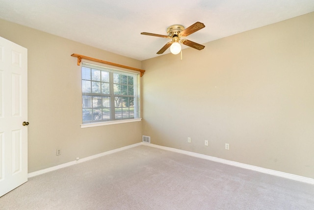 carpeted spare room featuring ceiling fan