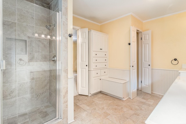 bathroom with a shower with door and ornamental molding