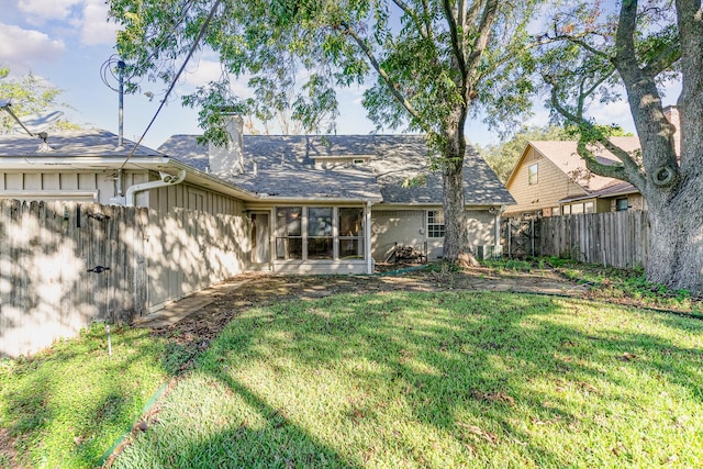 rear view of property with a lawn