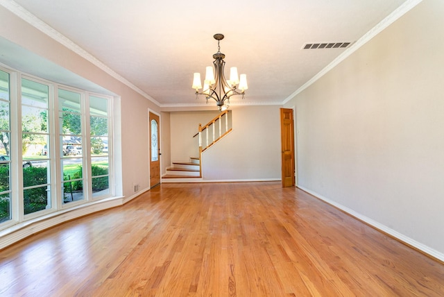 unfurnished living room with ornamental molding, light wood-type flooring, and a notable chandelier