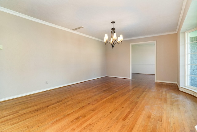 empty room featuring light wood-type flooring, crown molding, and a notable chandelier