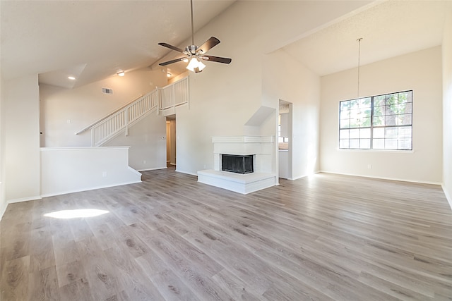 unfurnished living room featuring light hardwood / wood-style floors, high vaulted ceiling, and ceiling fan