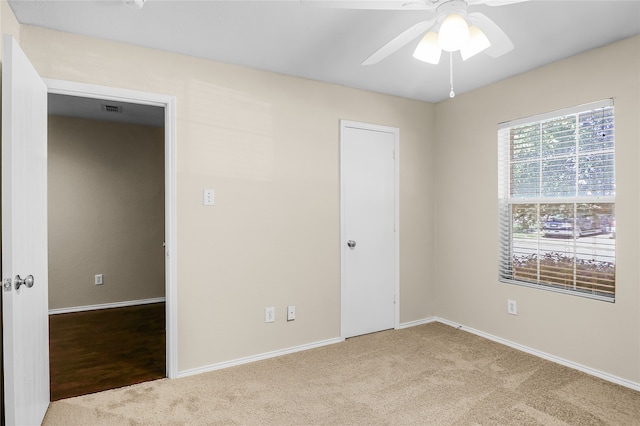 spare room featuring ceiling fan and light carpet