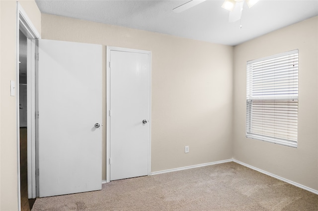 unfurnished bedroom featuring ceiling fan and light colored carpet