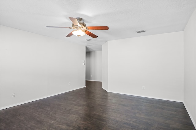 unfurnished room with ceiling fan, a textured ceiling, and dark wood-type flooring