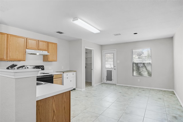 kitchen with light tile patterned flooring, light brown cabinets, and electric range