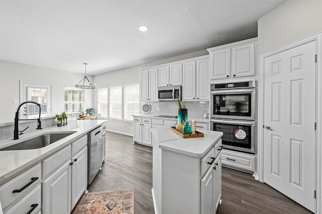 kitchen featuring dark hardwood / wood-style flooring, white cabinetry, sink, and appliances with stainless steel finishes