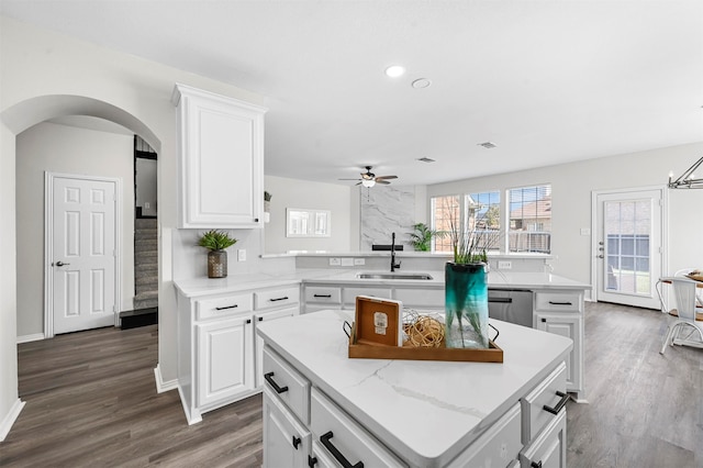 kitchen featuring ceiling fan, white cabinetry, sink, and a kitchen island