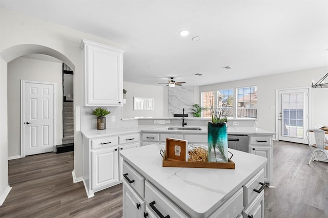 kitchen with sink, a center island, and white cabinets