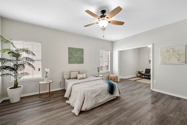 bedroom featuring dark hardwood / wood-style floors, ceiling fan, and multiple windows