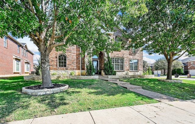 obstructed view of property with brick siding and a front lawn