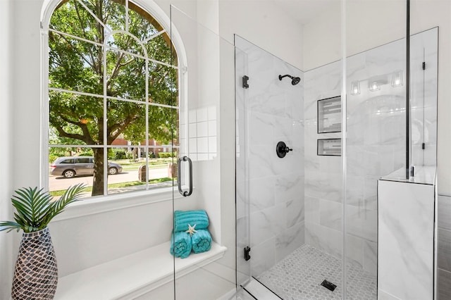 bathroom with an enclosed shower and a healthy amount of sunlight