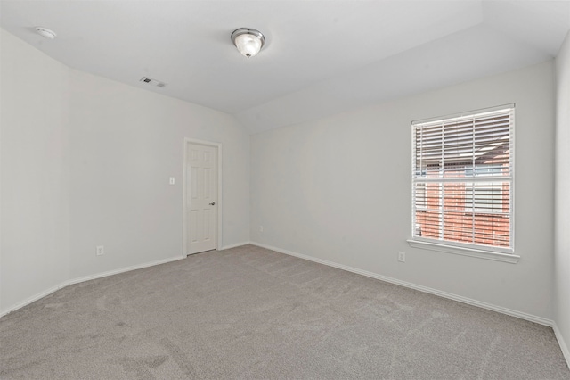 carpeted spare room with vaulted ceiling