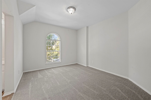 unfurnished room featuring carpet flooring and vaulted ceiling