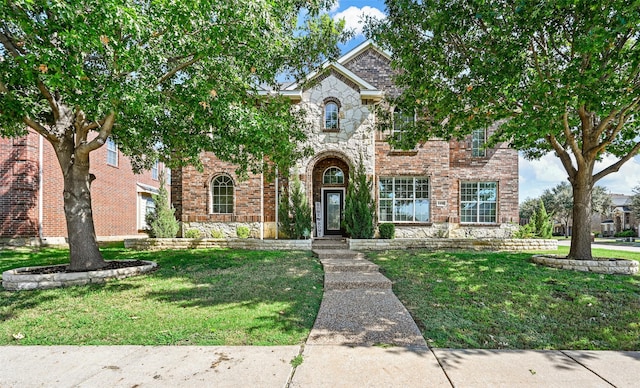 view of front facade featuring stone siding, brick siding, and a front yard