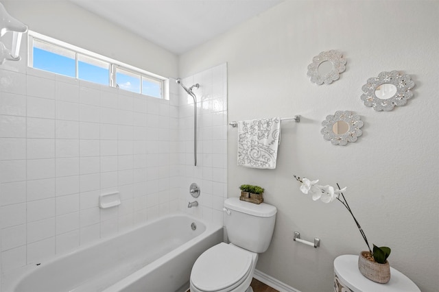 bathroom with tiled shower / bath and toilet