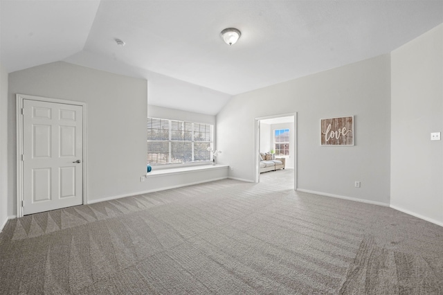 unfurnished living room with carpet and vaulted ceiling