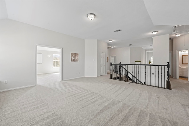 carpeted spare room with lofted ceiling