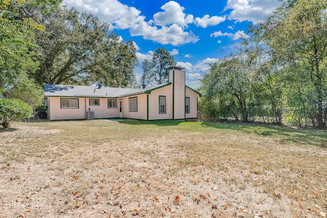 rear view of house featuring a yard and central AC unit