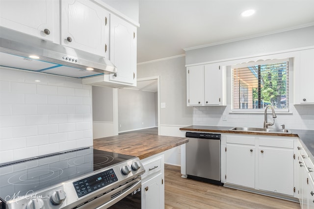 kitchen featuring sink, wood counters, stainless steel appliances, ornamental molding, and white cabinets