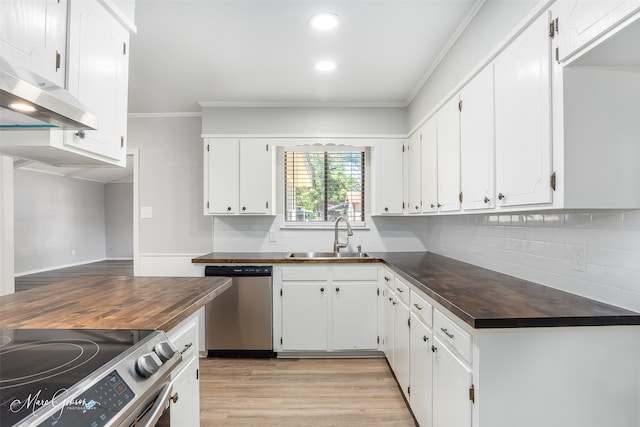 kitchen featuring appliances with stainless steel finishes, sink, wood counters, and white cabinetry