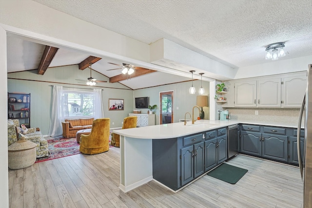 kitchen with sink, light hardwood / wood-style flooring, kitchen peninsula, decorative light fixtures, and appliances with stainless steel finishes