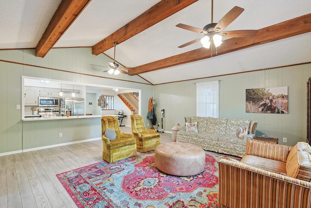 living room with vaulted ceiling with beams, ceiling fan, a healthy amount of sunlight, and light wood-type flooring