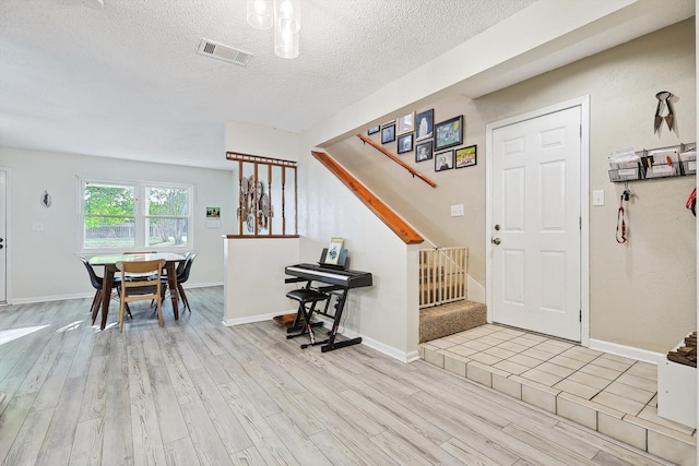 entrance foyer featuring light hardwood / wood-style floors and a textured ceiling