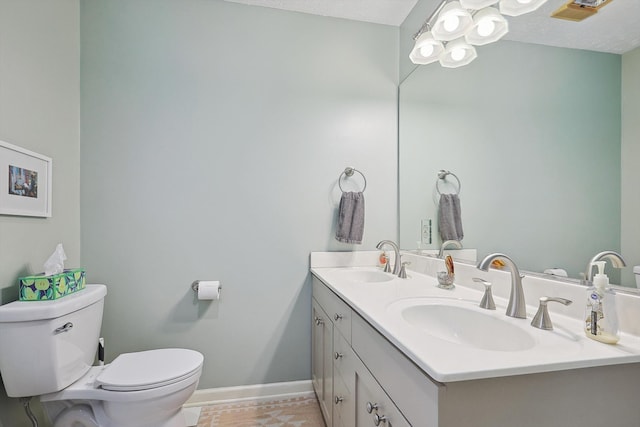 bathroom with vanity, a textured ceiling, and toilet