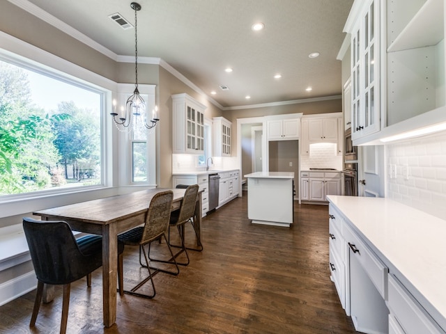 dining room with an inviting chandelier, crown molding, and dark hardwood / wood-style flooring