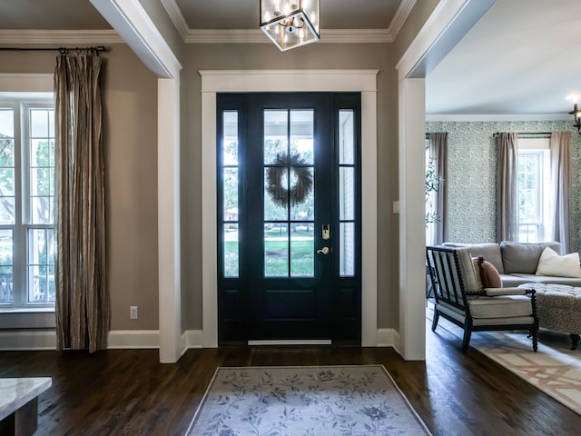 entrance foyer with ornamental molding, an inviting chandelier, and dark hardwood / wood-style flooring