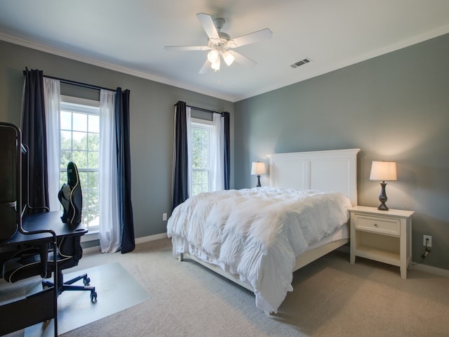 carpeted bedroom with ceiling fan, ornamental molding, and multiple windows