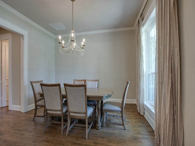 dining space featuring dark wood-type flooring, crown molding, and an inviting chandelier