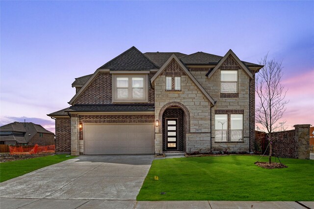 french country home featuring fence, roof with shingles, concrete driveway, a front yard, and a garage