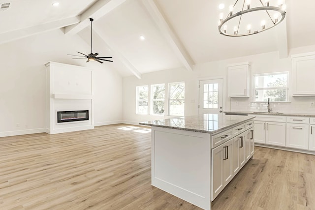 kitchen featuring a kitchen island, hanging light fixtures, light hardwood / wood-style floors, and white cabinetry