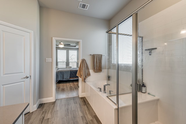 bathroom with independent shower and bath and wood-type flooring