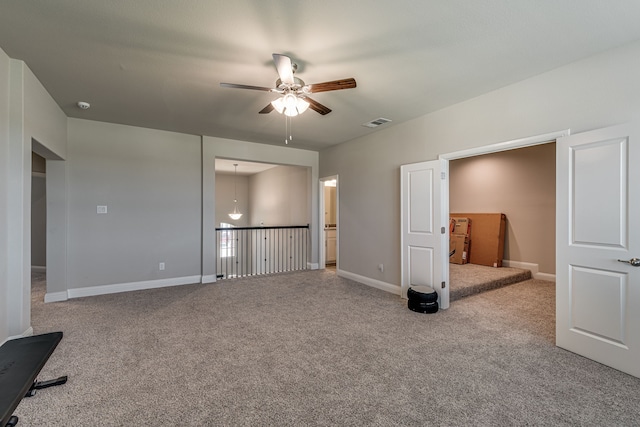 unfurnished bedroom featuring ceiling fan, ensuite bathroom, and light carpet