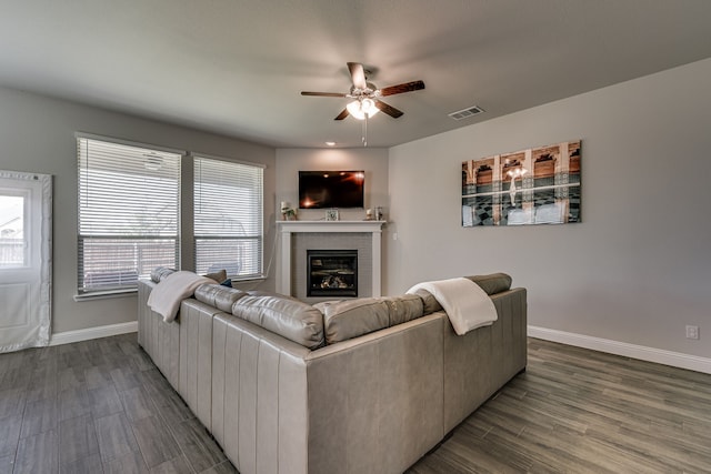 living room with ceiling fan, dark wood-type flooring, and a brick fireplace